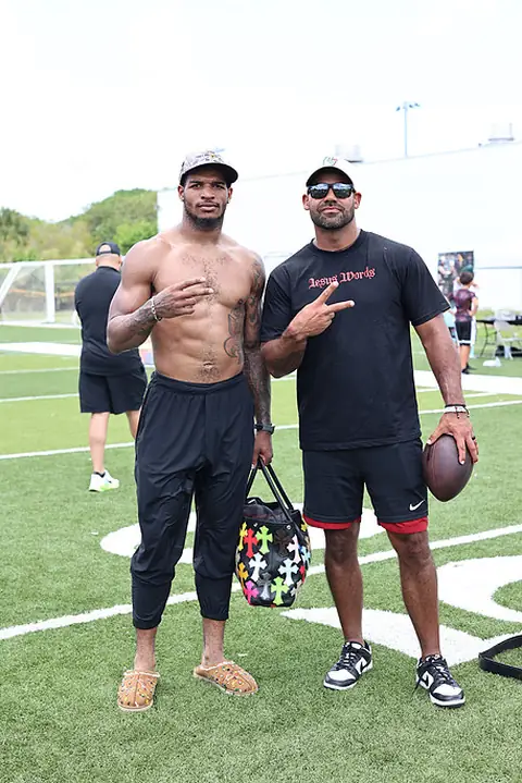 Craig LeBlanc with a pro football player at an outdoor camp